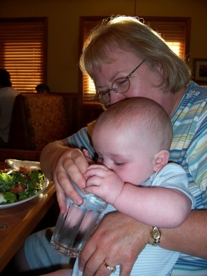 [Grandma Toni holding Andrew, drinking from a cup]