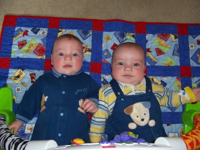 [Both boys sitting on a quilt]